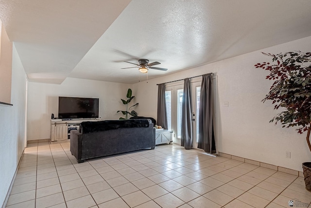 living room featuring a textured ceiling, ceiling fan, and light tile patterned flooring