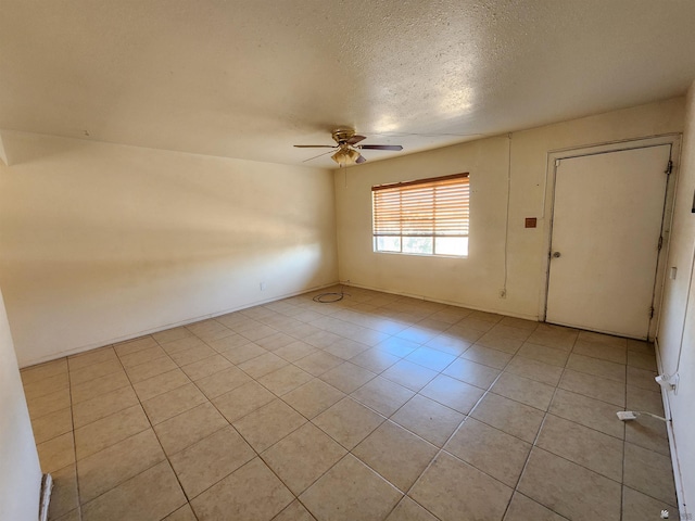 tiled empty room with ceiling fan and a textured ceiling