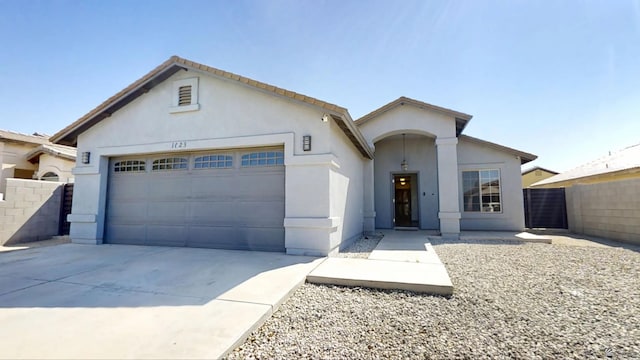 ranch-style house with stucco siding, driveway, an attached garage, and fence