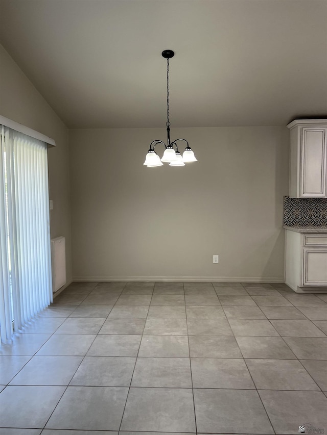 unfurnished dining area featuring light tile patterned floors, vaulted ceiling, and a notable chandelier