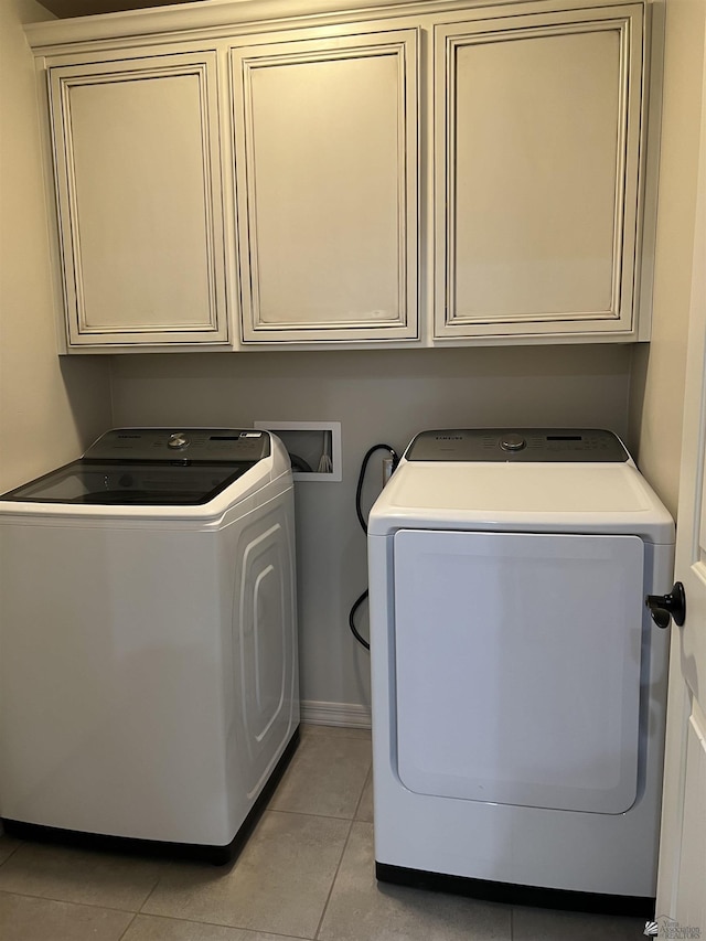 laundry room with cabinets, separate washer and dryer, and light tile patterned floors