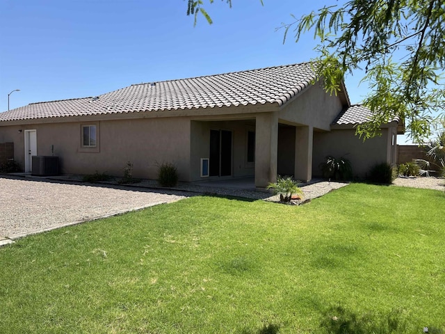 rear view of house with a lawn, cooling unit, and a patio