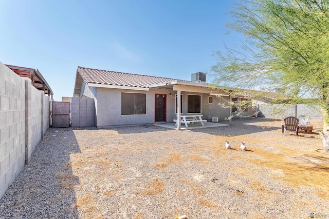 rear view of house featuring a patio area, a fenced backyard, stucco siding, and a tiled roof