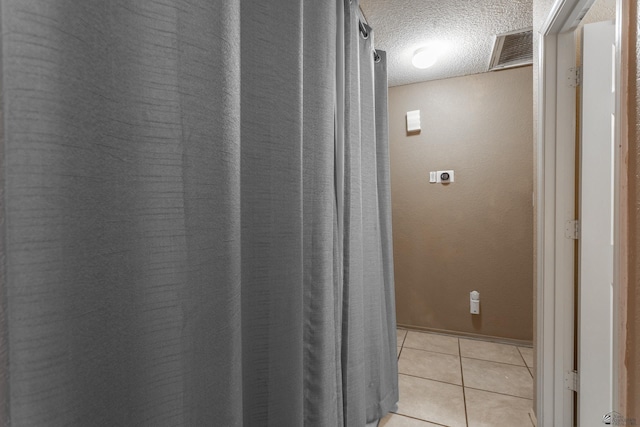 bathroom with tile patterned flooring, visible vents, and a textured ceiling