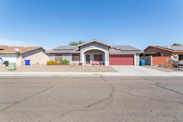 view of front of home featuring roof mounted solar panels, stucco siding, driveway, and a tile roof