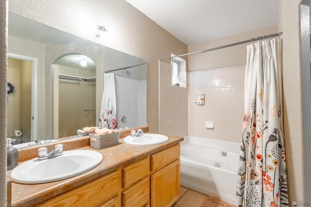 bathroom featuring a sink, shower / bathtub combination with curtain, double vanity, and tile patterned floors