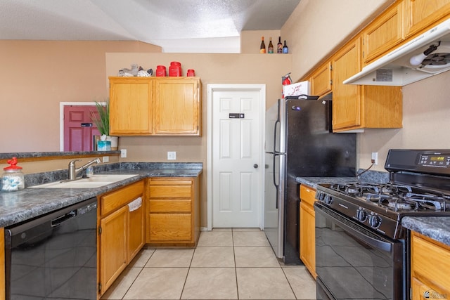 kitchen with light tile patterned floors, a sink, black appliances, under cabinet range hood, and dark countertops