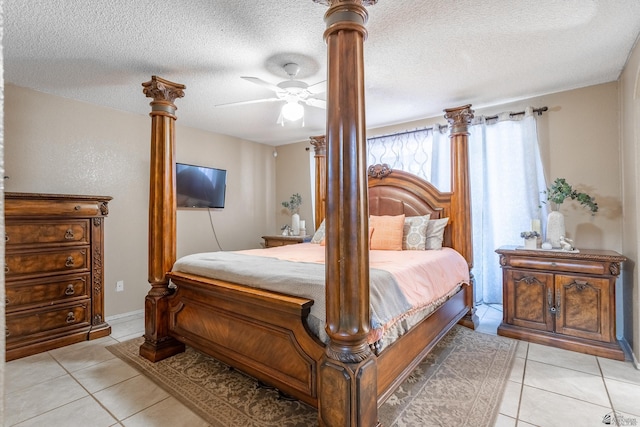 bedroom with ceiling fan, light tile patterned flooring, decorative columns, and a textured ceiling