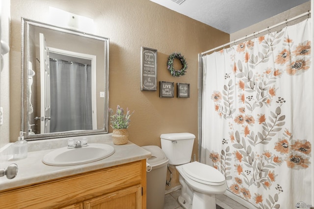 full bathroom featuring tile patterned flooring, toilet, vanity, and a textured wall