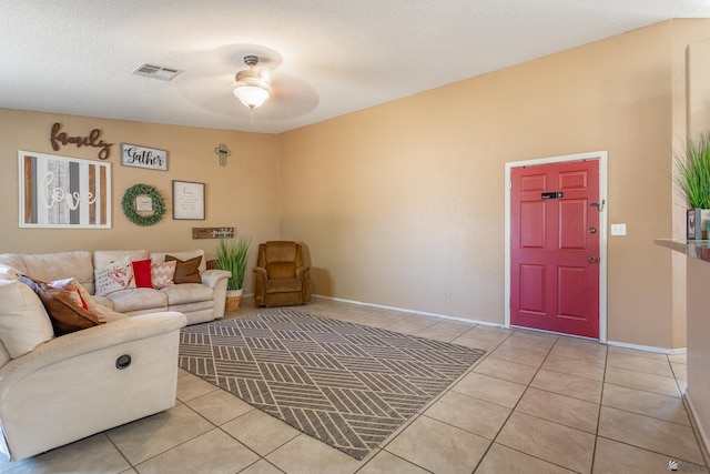 living area with light tile patterned floors, visible vents, a textured ceiling, and baseboards