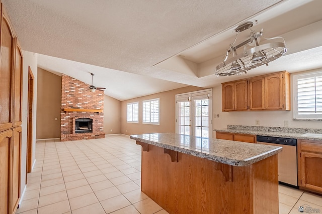 kitchen featuring light tile patterned floors, a breakfast bar, ceiling fan, dishwasher, and a center island