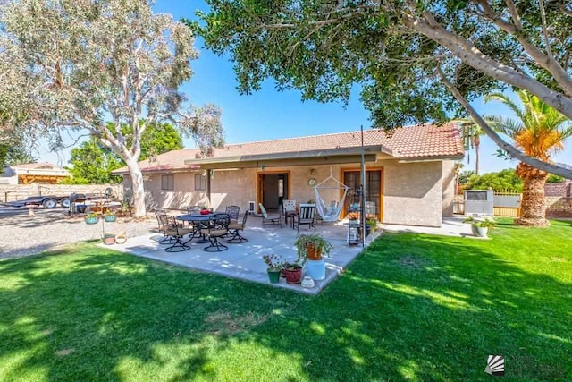 back of house with a yard and a patio