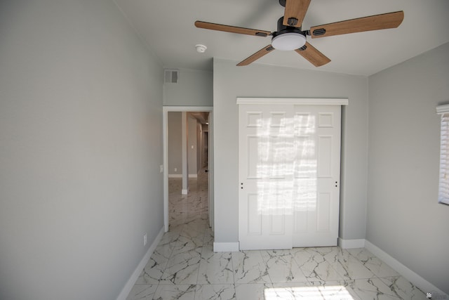 unfurnished bedroom featuring ceiling fan and a closet