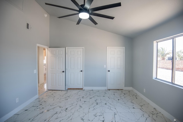 unfurnished bedroom with high vaulted ceiling, two closets, and ceiling fan