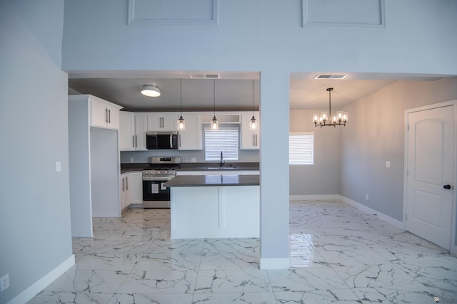 kitchen with decorative light fixtures, a notable chandelier, white cabinets, appliances with stainless steel finishes, and sink