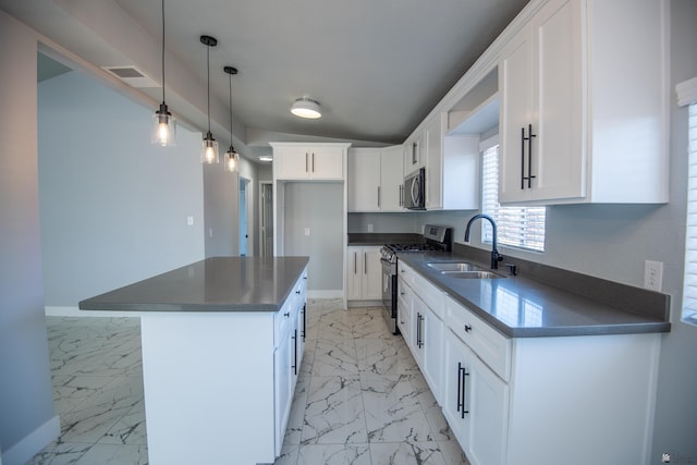 kitchen featuring sink, stainless steel appliances, a center island, and white cabinetry