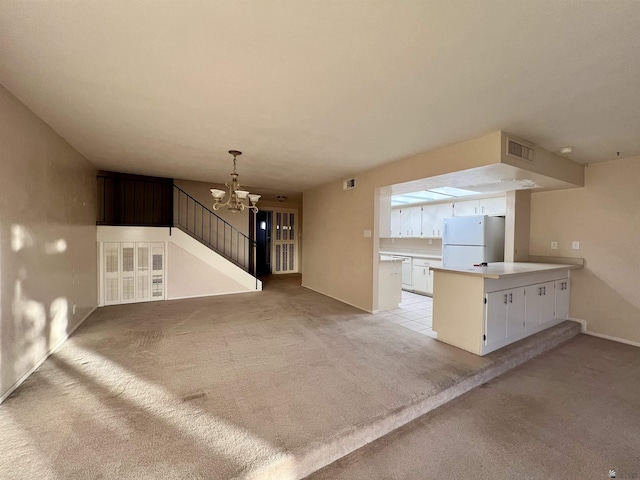 unfurnished living room featuring light carpet and a notable chandelier