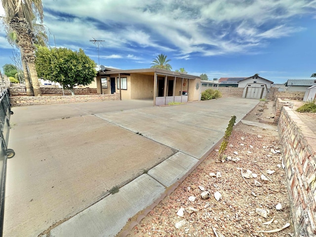 ranch-style house with a garage and an outbuilding