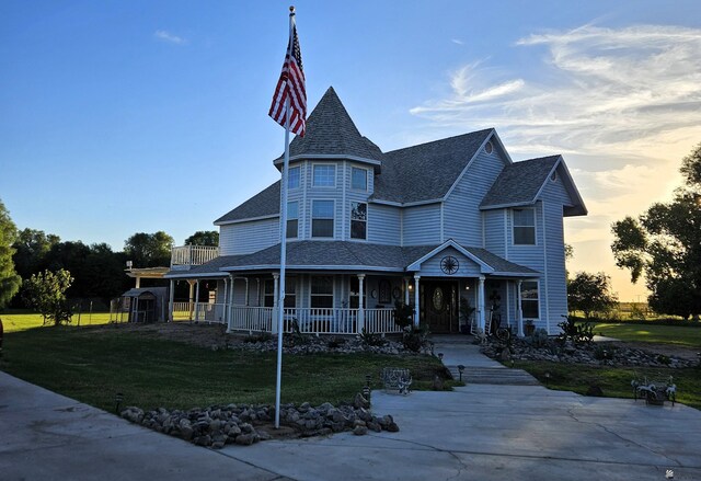 victorian-style house with a porch and a yard