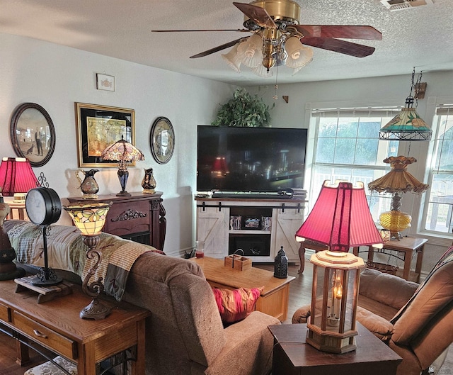 living room featuring a textured ceiling, hardwood / wood-style floors, and a healthy amount of sunlight