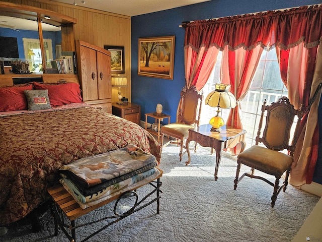 carpeted bedroom with wood walls