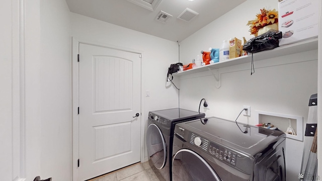 washroom with light tile patterned floors and washing machine and clothes dryer