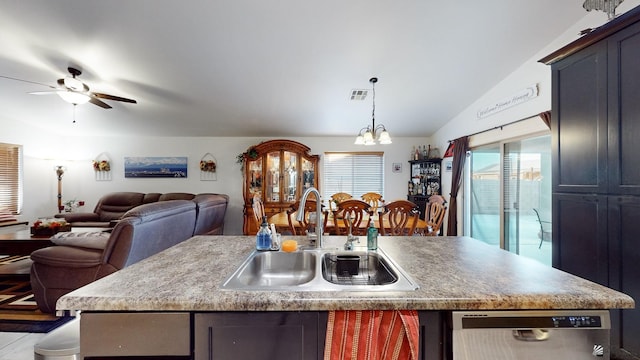 kitchen featuring lofted ceiling, dishwasher, sink, a kitchen island with sink, and ceiling fan with notable chandelier