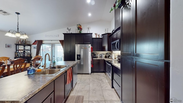 kitchen featuring a center island with sink, stainless steel appliances, a notable chandelier, vaulted ceiling, and sink