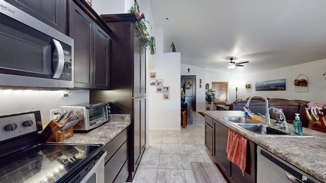 kitchen with ceiling fan, appliances with stainless steel finishes, light tile patterned flooring, dark brown cabinetry, and sink