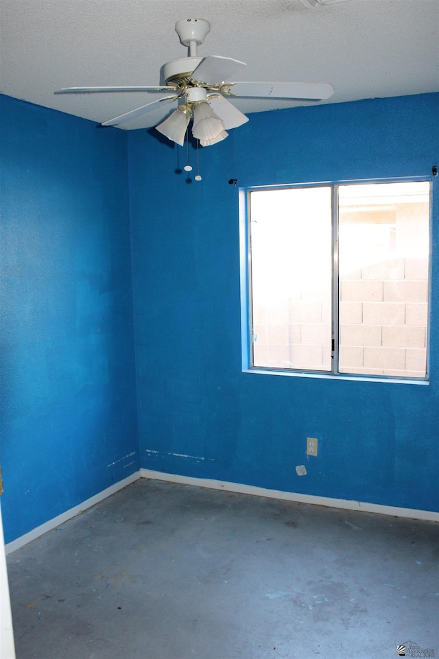 empty room featuring ceiling fan and concrete flooring