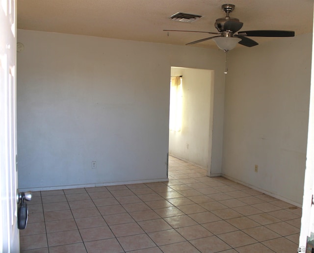 tiled spare room with ceiling fan