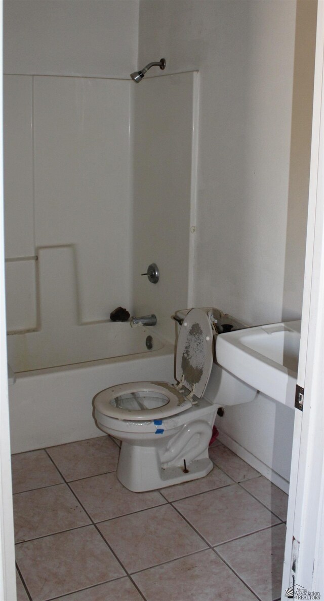 bathroom featuring tile patterned flooring, bathtub / shower combination, and toilet