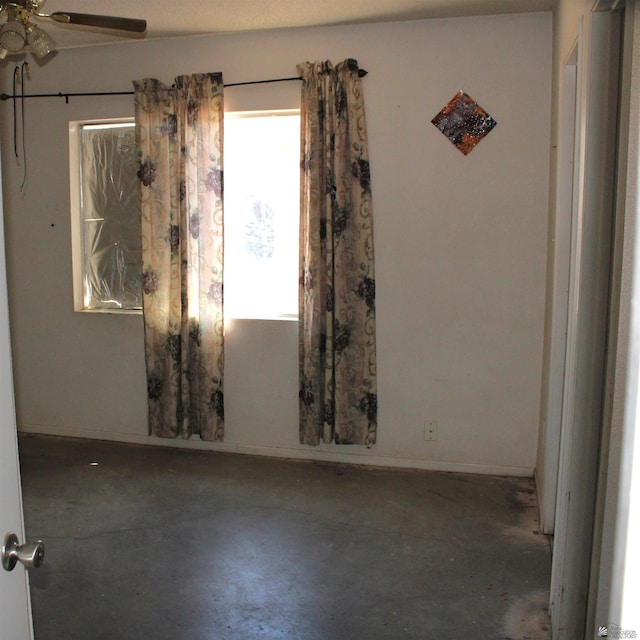 empty room featuring concrete floors and ceiling fan