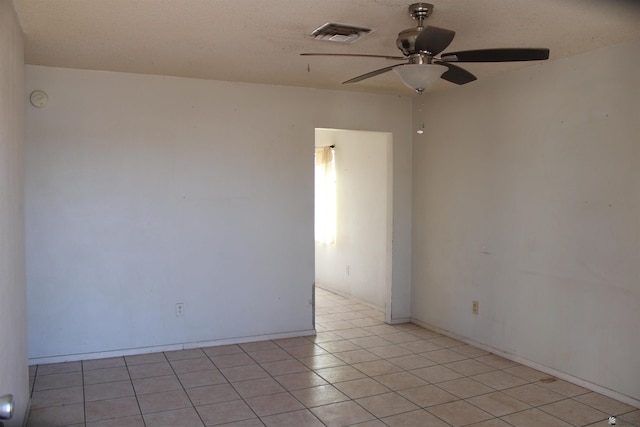 unfurnished room with ceiling fan, light tile patterned floors, and a textured ceiling