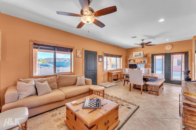 tiled living room with french doors and ceiling fan