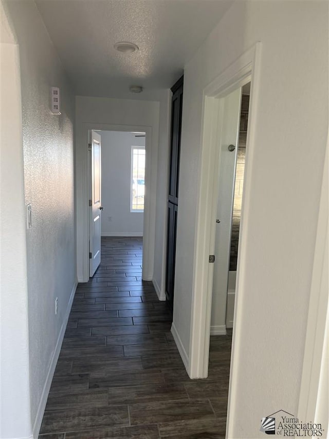 hall featuring dark hardwood / wood-style flooring and a textured ceiling