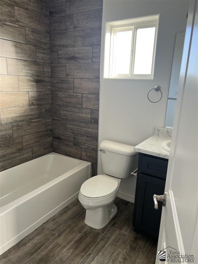 full bathroom featuring vanity, tiled shower / bath combo, and toilet