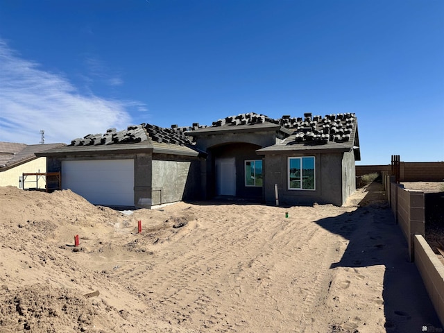 property in mid-construction featuring fence, a garage, and stucco siding