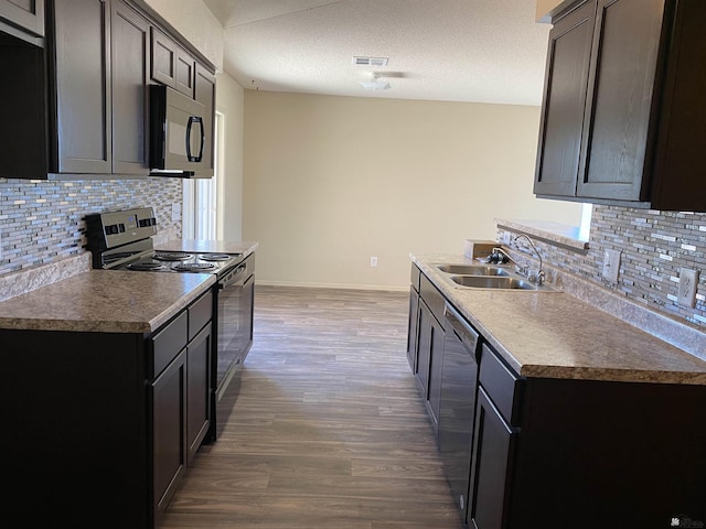 kitchen with backsplash, a textured ceiling, stainless steel appliances, sink, and dark hardwood / wood-style floors