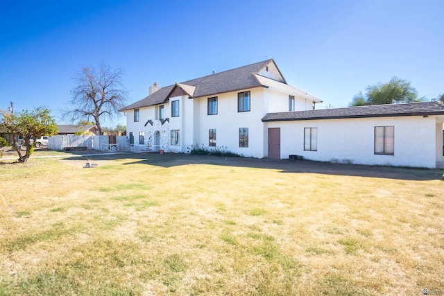 rear view of house featuring a lawn