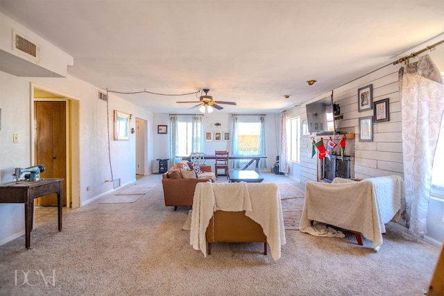 living room with light carpet, ceiling fan, and wood walls