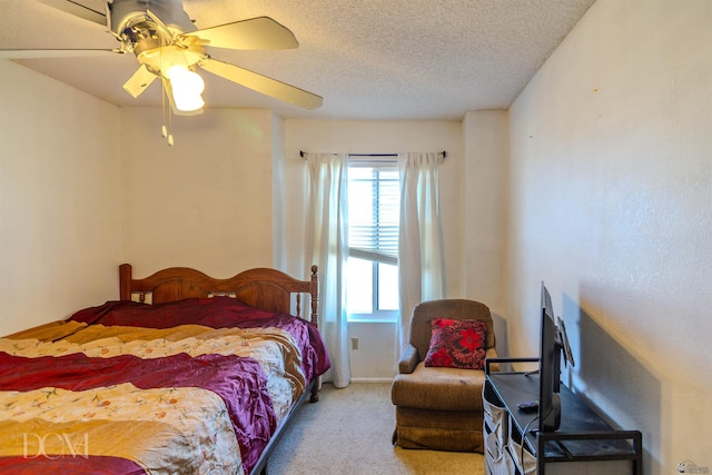 bedroom featuring multiple windows, a textured ceiling, light colored carpet, and ceiling fan