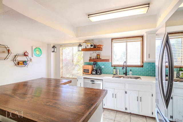 kitchen featuring a wealth of natural light, sink, white cabinets, and stainless steel appliances