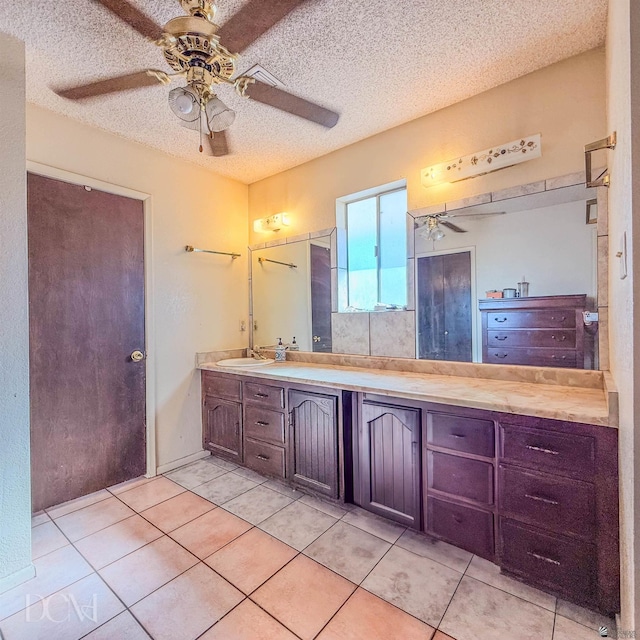 bathroom with tile patterned flooring, vanity, and a textured ceiling