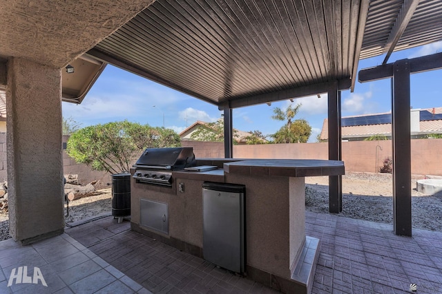 view of patio / terrace featuring area for grilling, an outdoor kitchen, and a fenced backyard