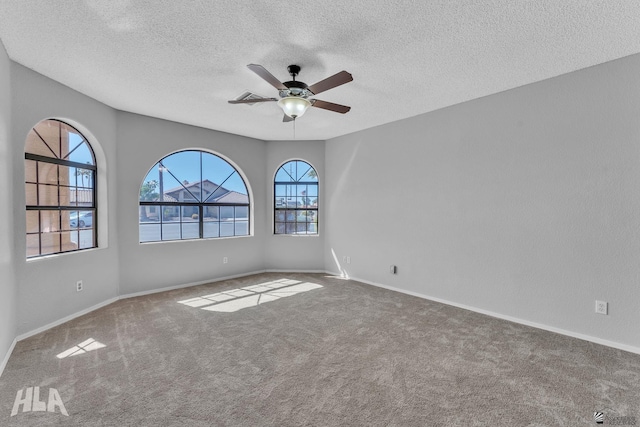 unfurnished room featuring carpet flooring, ceiling fan, a textured ceiling, and baseboards