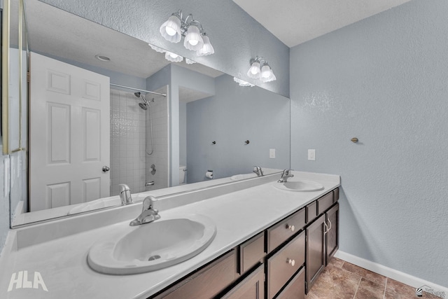 full bath with toilet, a sink, baseboards, and double vanity