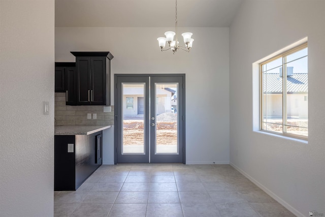 kitchen with pendant lighting, decorative backsplash, plenty of natural light, and an inviting chandelier