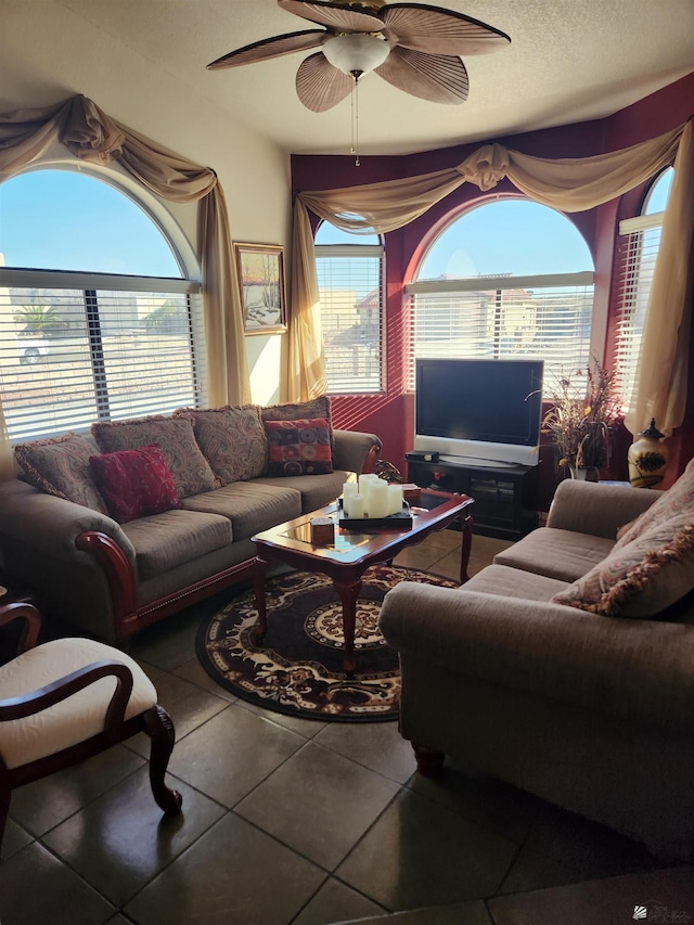 tiled living room with ceiling fan and a textured ceiling