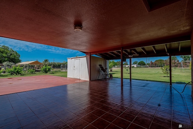 view of patio with a storage shed, fence, and an outbuilding